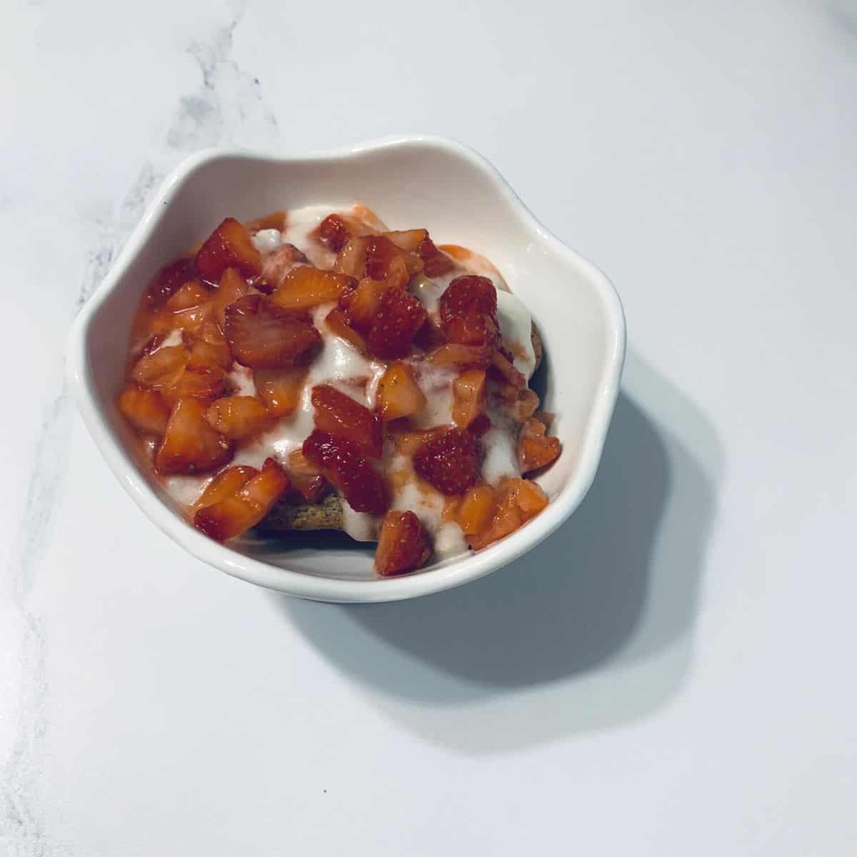 Homemade strawberry shortcake made with gluten free ingredients in  a white dish on a table.