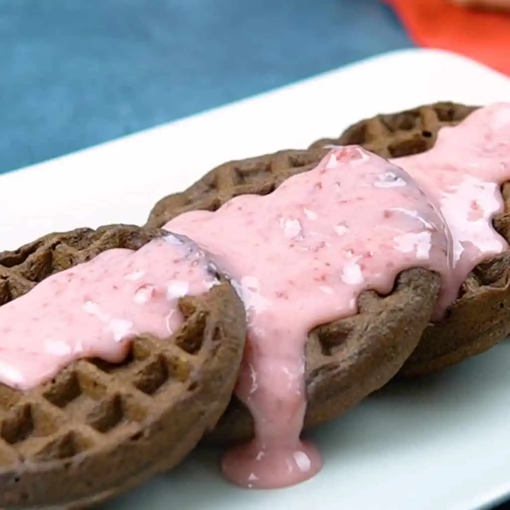 Paleo and gluten free chocolate waffle dippers recipe topped with strawberry dipping sauce.