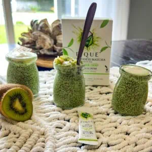 Pique sun goddess matcha chia seed pudding on a table in the summer.