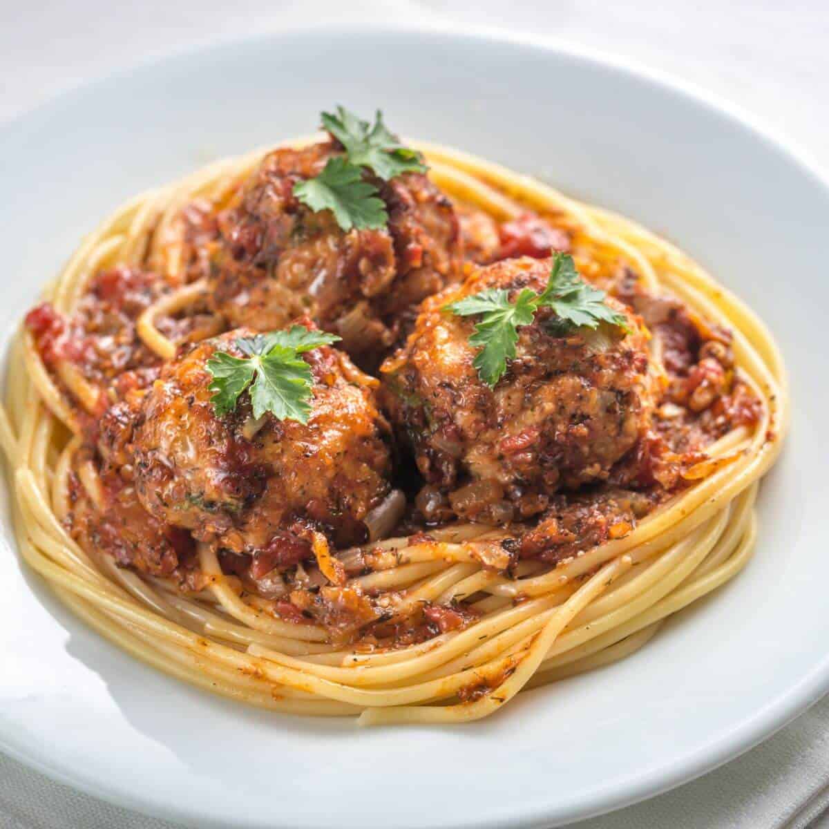 white plate of easy paleo turkey zucchini meatballs recipe with gluten free spaghetti